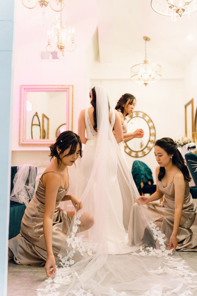 Wedding Timeline Without a Planner: Bridesmaids helping the bride with her wedding dress