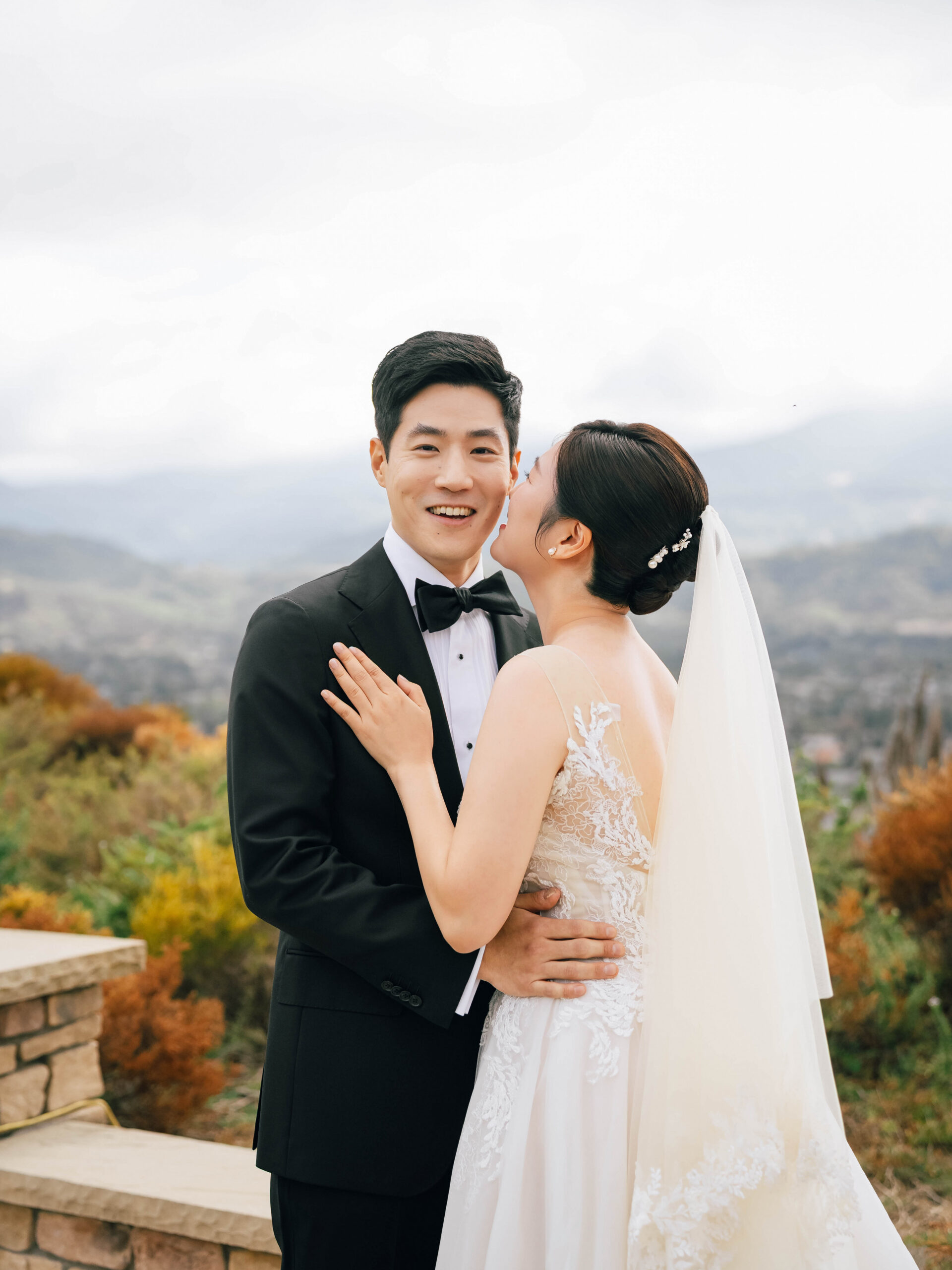 Bride kissing the groom’s cheek during their wedding portraits.