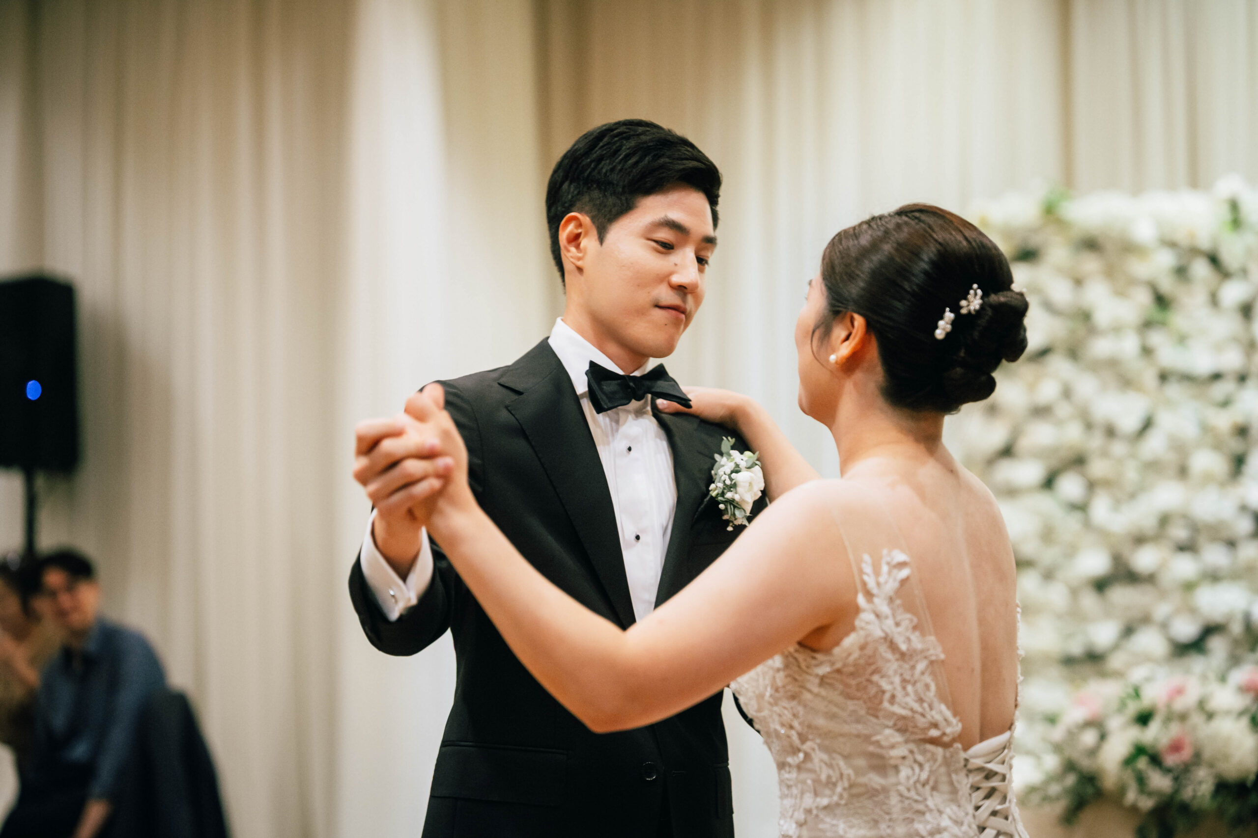 Bride and groom holding hands during their first dance.