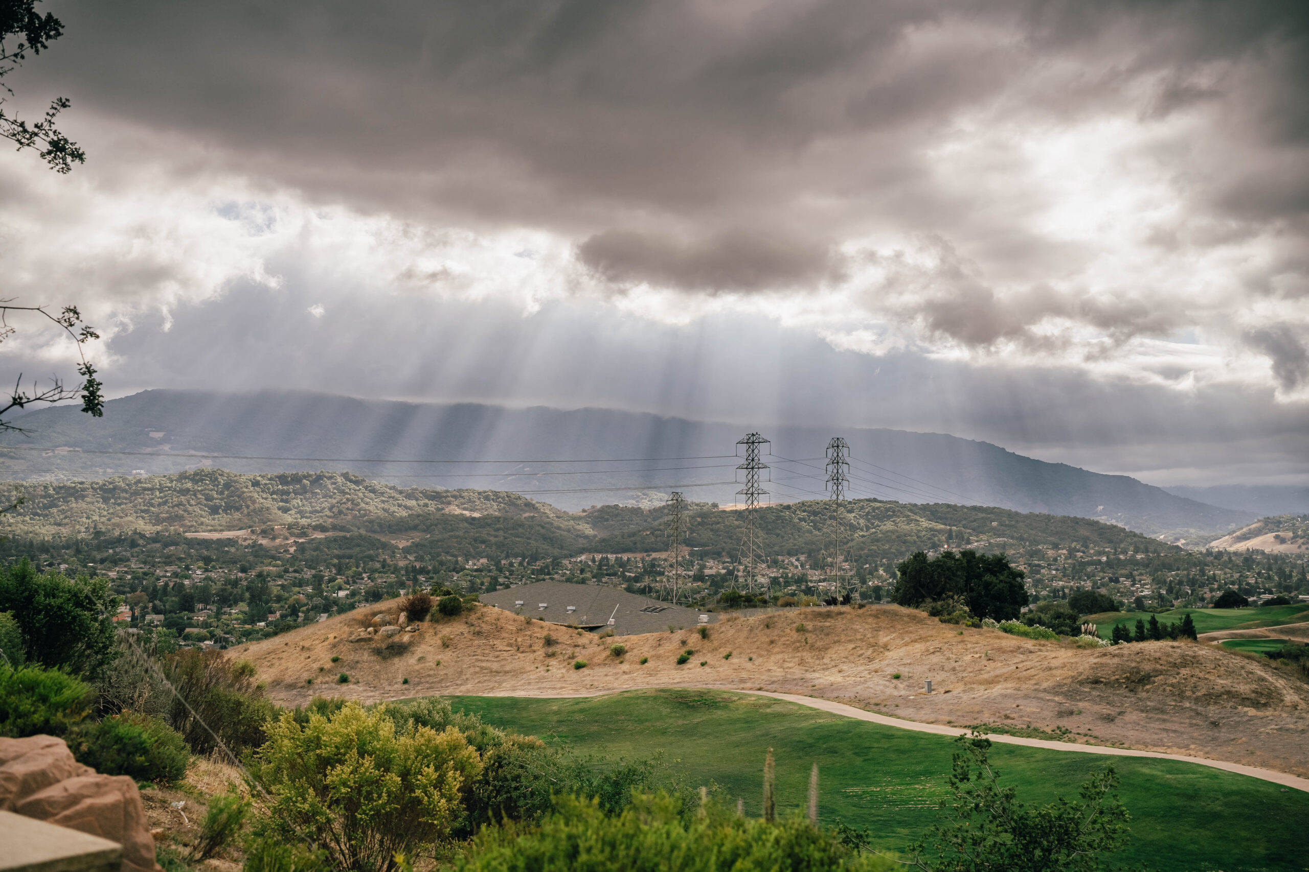 Clouds and shafts of light above the rolling hills at Boulder Ridge Golf Club.