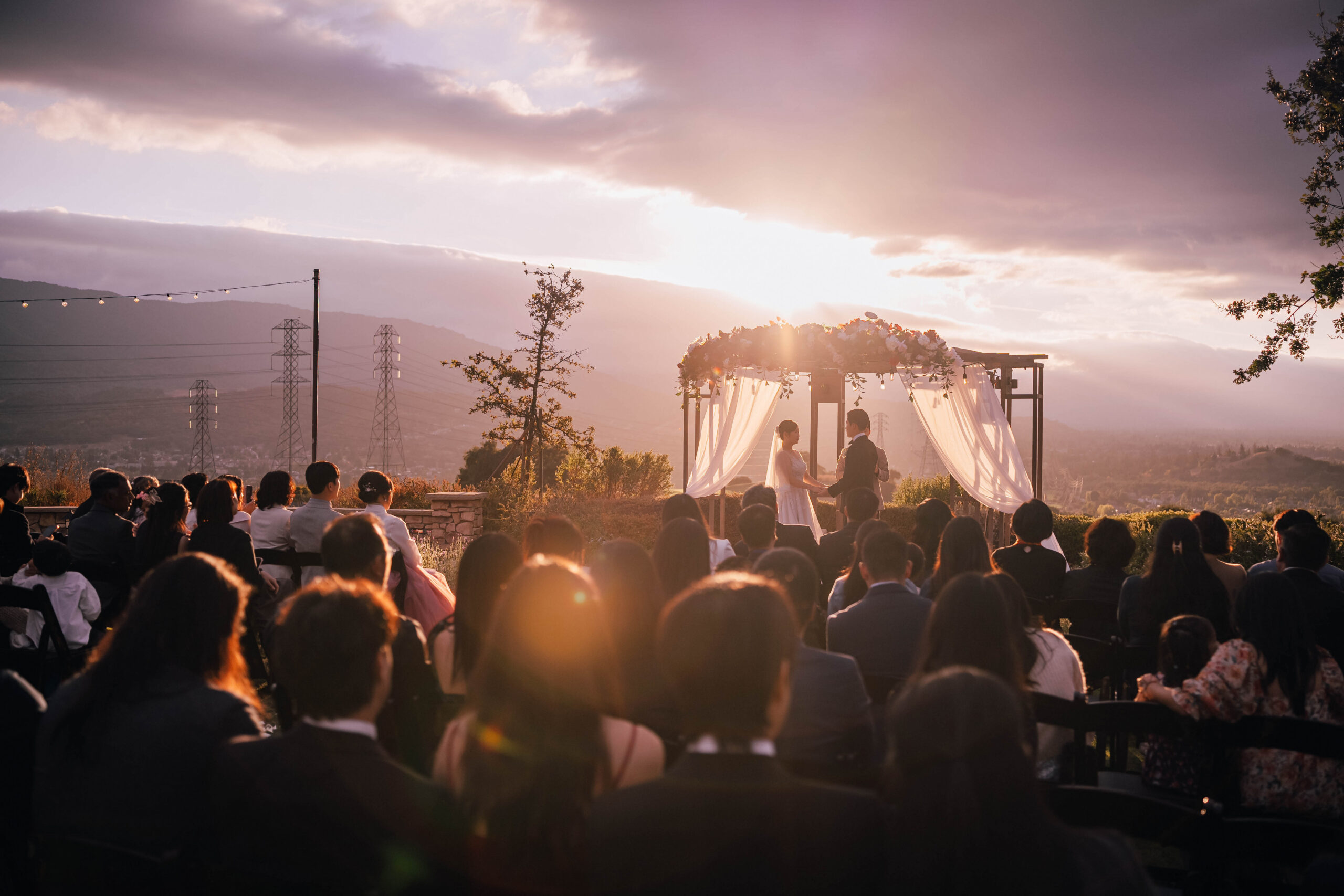 Sunlight breaking through clouds over a Boulder Ridge Golf Club wedding ceremony.