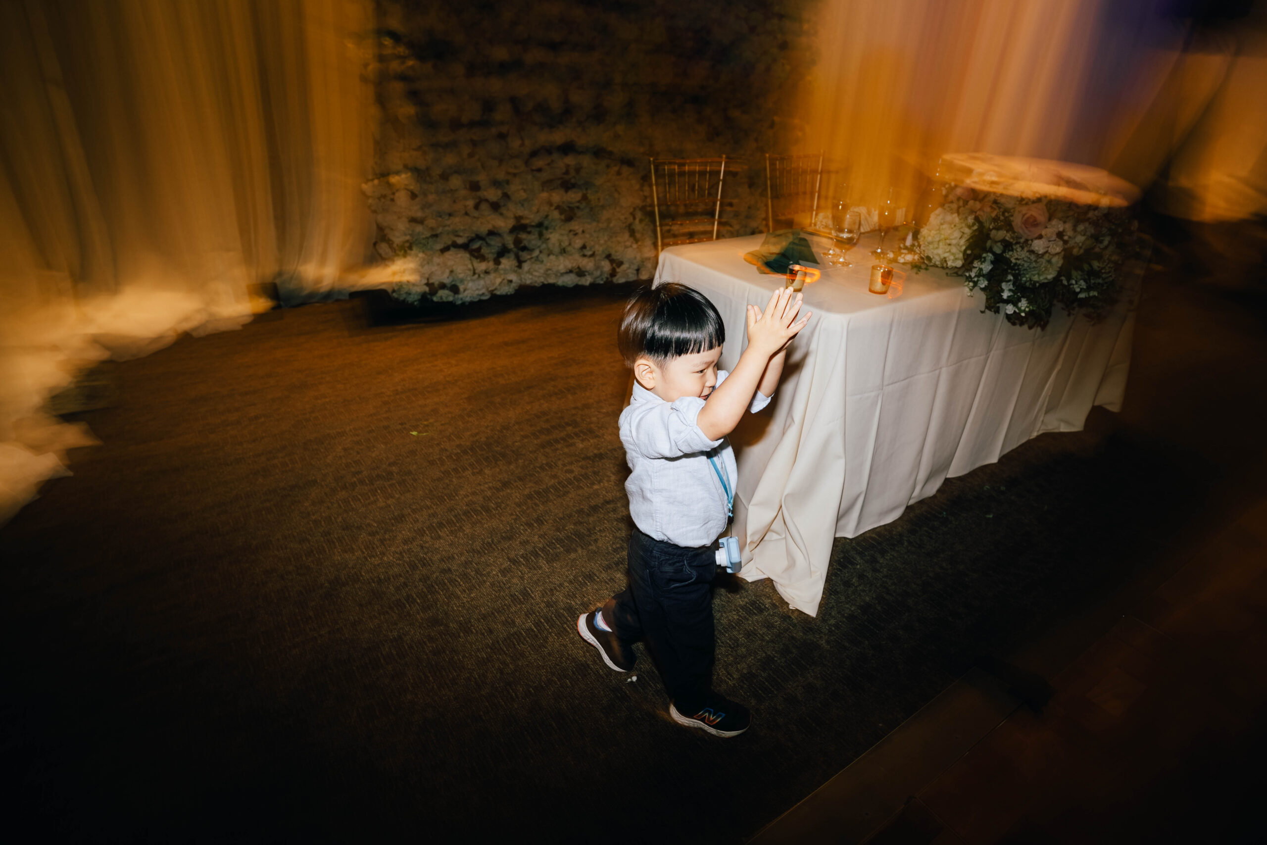 Young wedding guest clapping his hands while dancing at the reception.