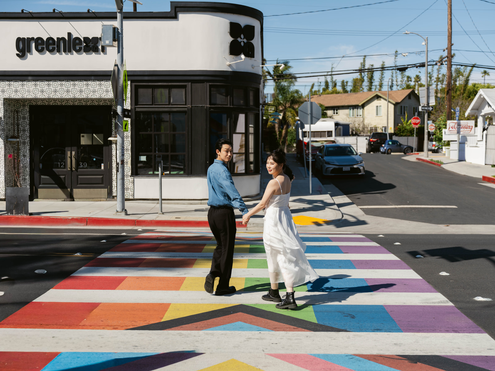 Couple holding hands on a rainbow crosswalk in Venice